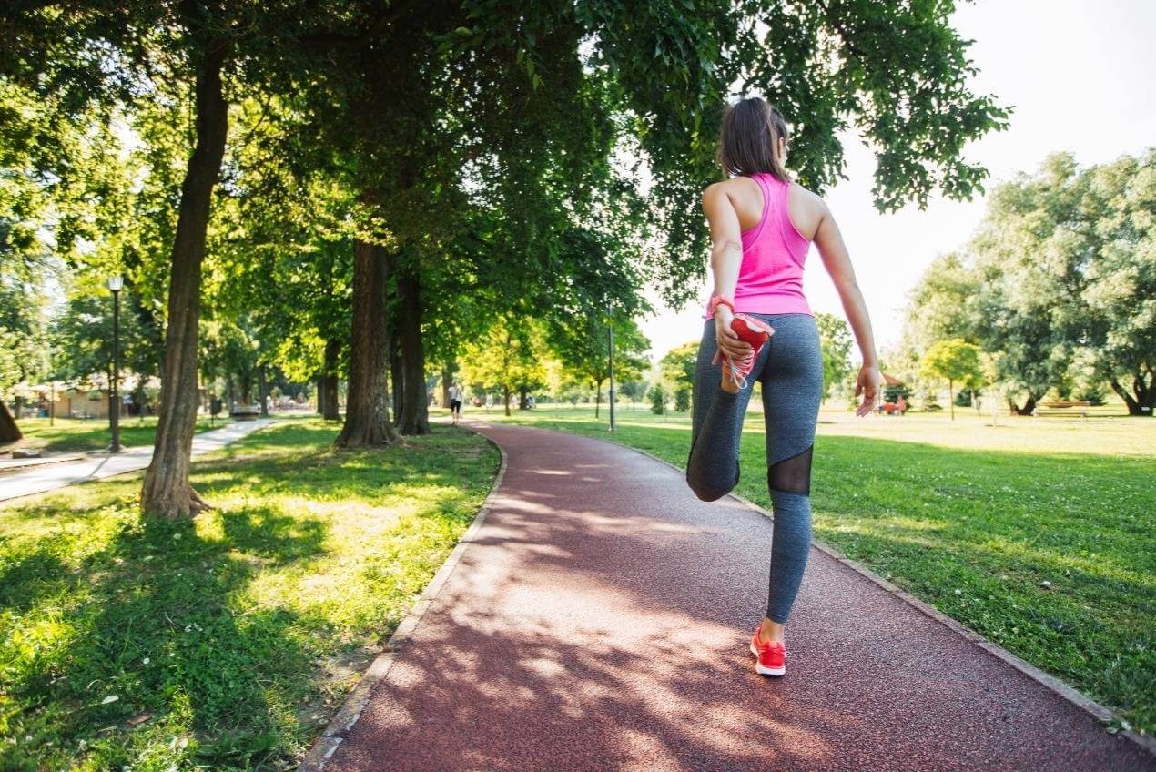 Young woman stretching her quad before a run 