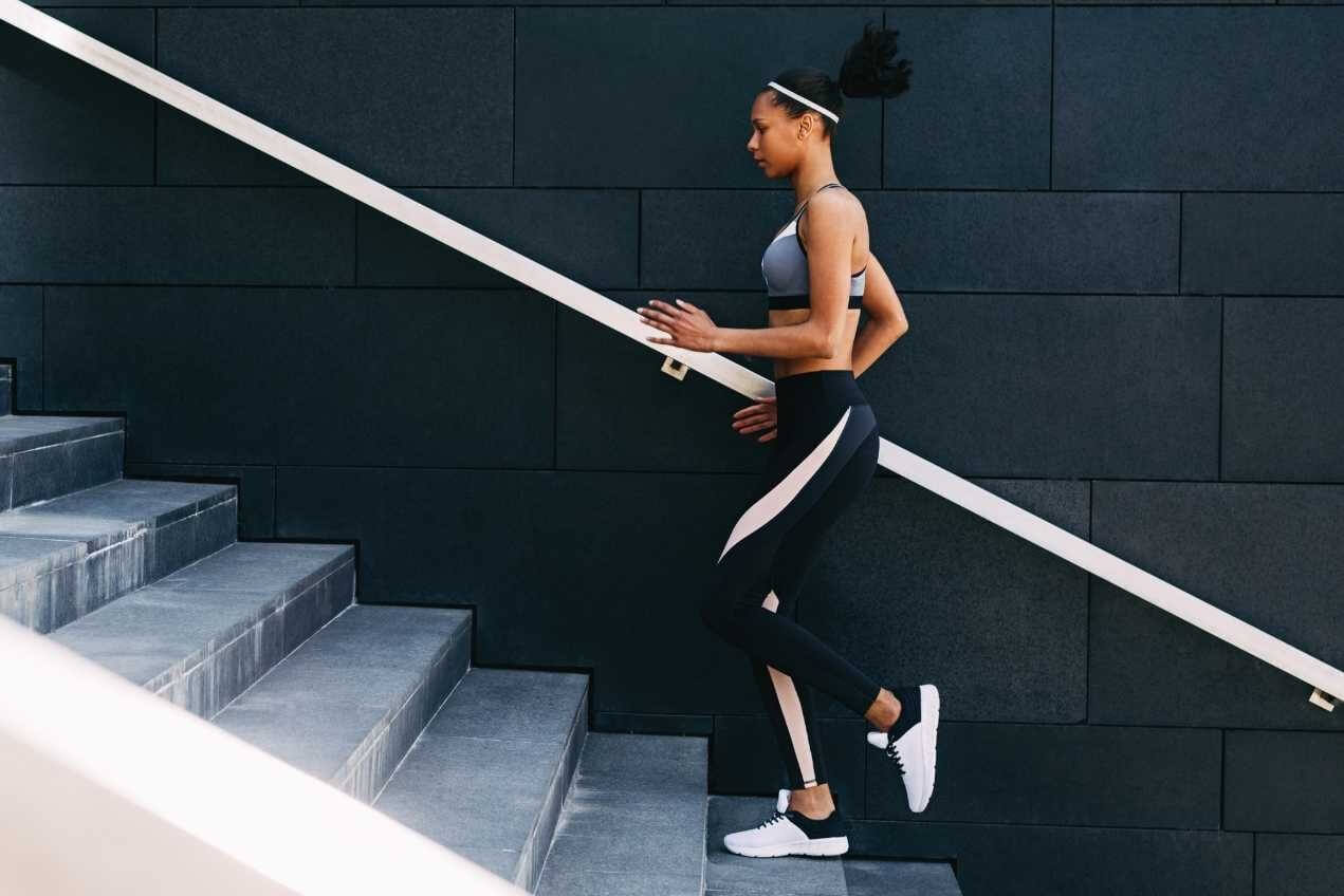 Woman in activewear running up stairs
