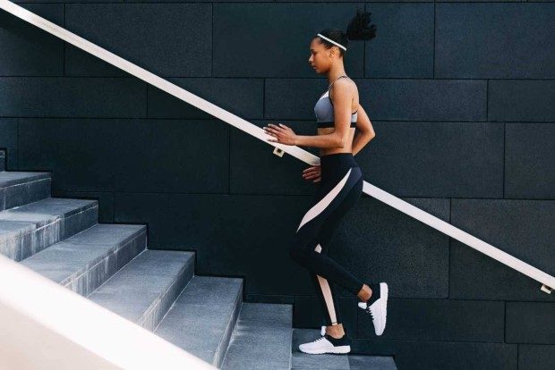 A young woman in activewear running up stairs