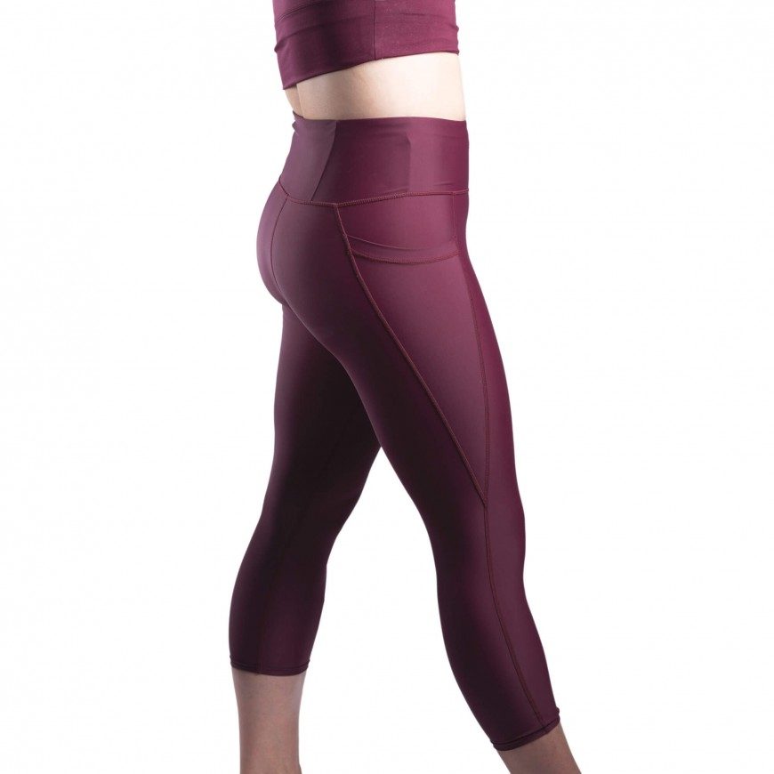 Side view of a woman's legs wearing purple maroon activewear