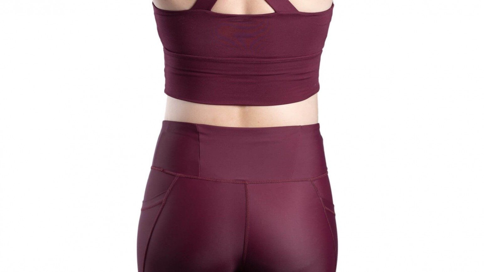 A woman's lower back wearing purple maroon activewear