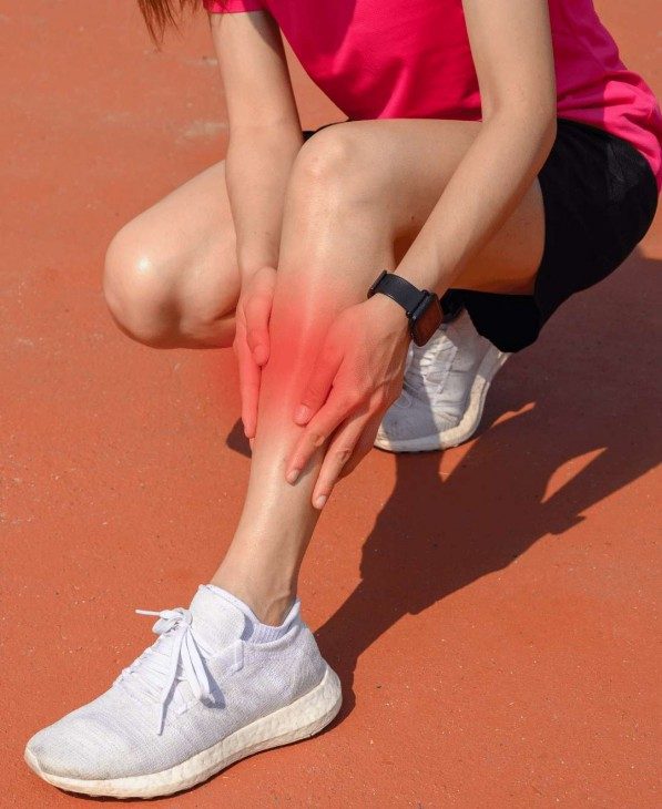 Woman holding her leg because of shin splints pain and symptoms